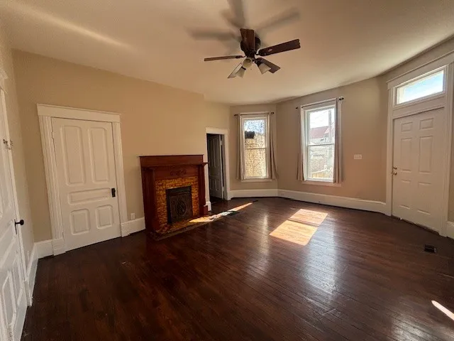 a view of a livingroom with a fireplace wooden floor and window