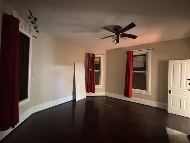 a view of a livingroom with a ceiling fan window and wooden floor