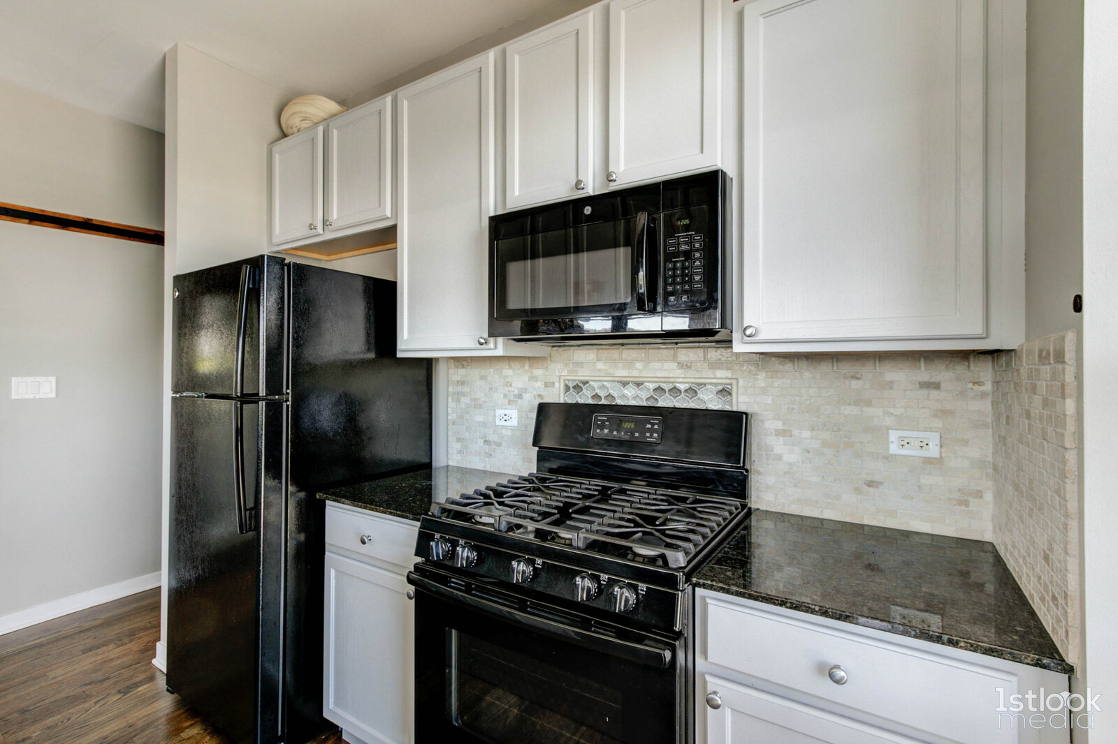 1033 West 14th Place, Unit 413 Chicago, IL 60608 - Photo 7 of 42 a kitchen with stainless steel appliances granite countertop white cabinets a refrigerator stove and microwave