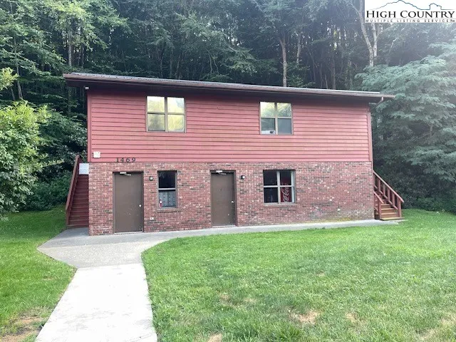 a front view of a house with a yard and trees