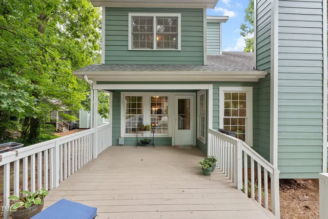 an aerial view of residential houses with outdoor space and trees