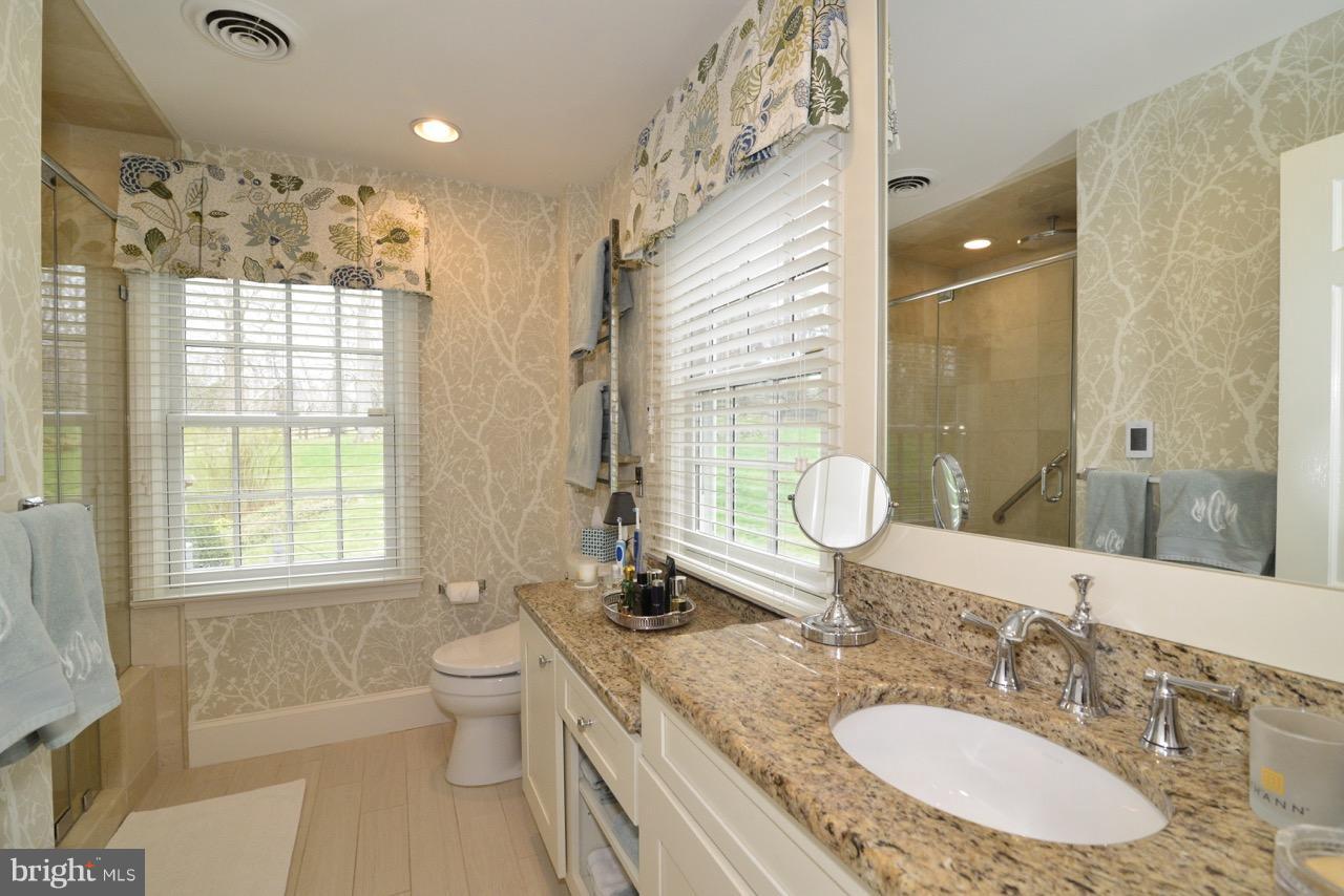 3072 Swift Shoals Road Boyce, VA 22620 - Photo 22 of 30 a bathroom with a granite countertop double vanity sink a mirror and a toilet