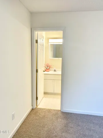 a view of a hallway with a white cabinet and a refrigerator