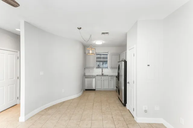 a kitchen with stainless steel appliances a refrigerator sink and cabinets