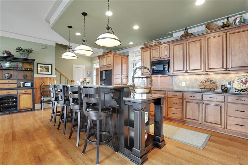 79 Strawberry Way Jasper, GA 30143 - Photo 11 of 67 a kitchen with stainless steel appliances granite countertop a stove top oven a sink a dining table and chairs with wooden floor