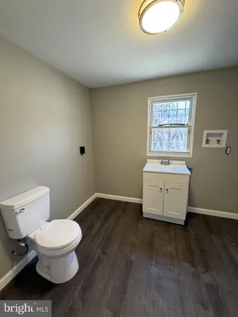 a bathroom with a toilet a sink and mirror