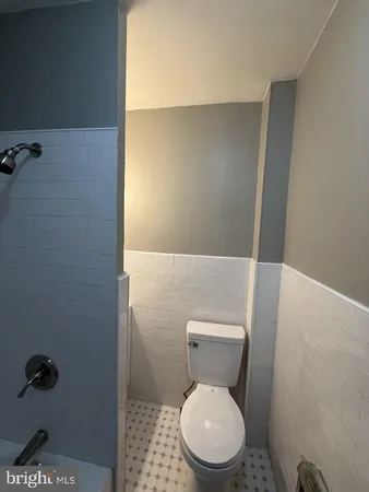 a white toilet sitting next to a shower