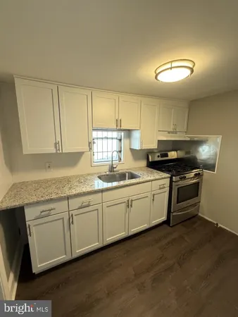 a kitchen with granite countertop a sink and cabinets