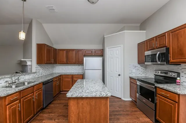 a kitchen with stainless steel appliances granite countertop a sink stove and refrigerator