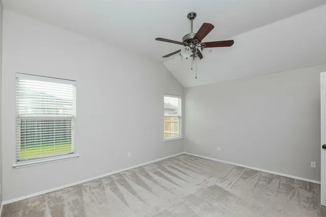 a view of empty room with window and ceiling fan