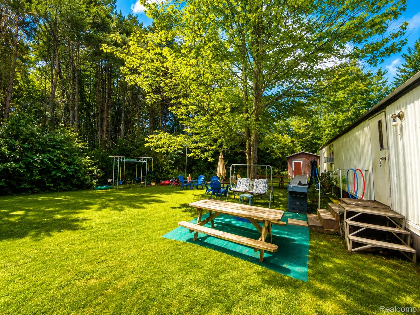 643 North Hockaday Road Gladwin, MI 48624 - Photo 2 of 24 Expansive green lawn surrounded by mature trees, providing a natural perimeter