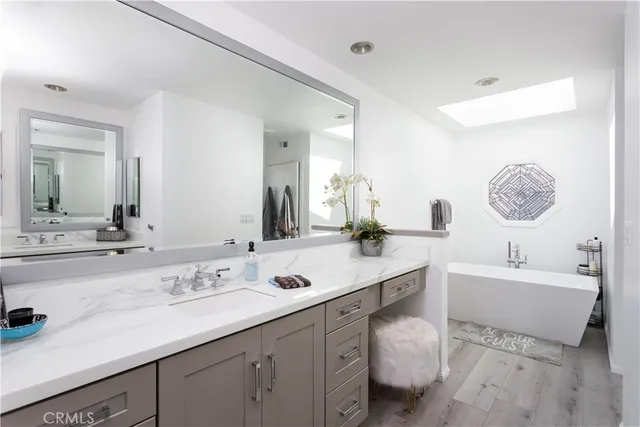 a spacious bathroom with a double vanity sink mirror and bathtub