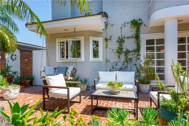 a view of a patio with table and chairs potted plants and wooden fence