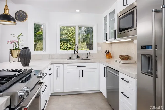 a kitchen with stainless steel appliances a sink stove and refrigerator
