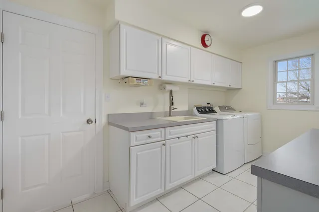a kitchen with white cabinets and sink