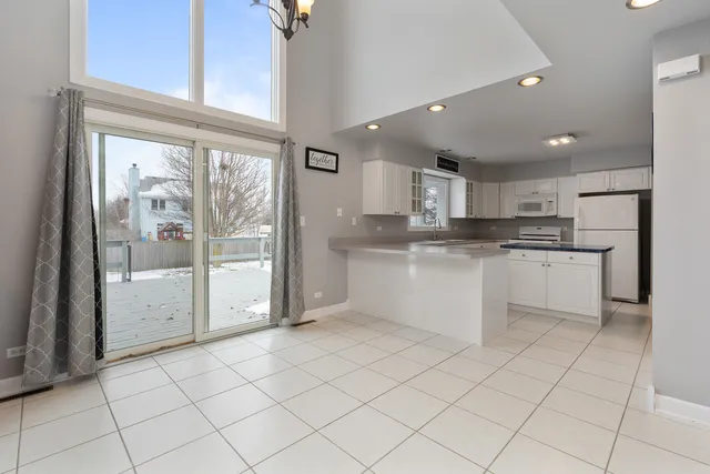 a kitchen with white cabinets and a refrigerator