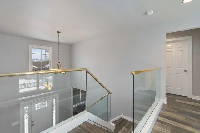 a view of a hallway with entryway a dining table and chairs