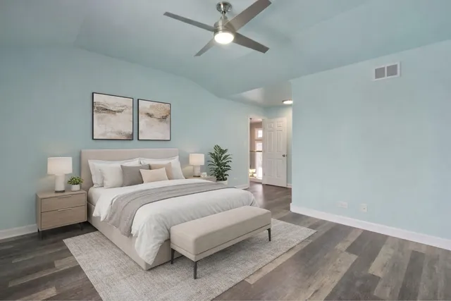 a spacious bedroom with a bed and a chandelier