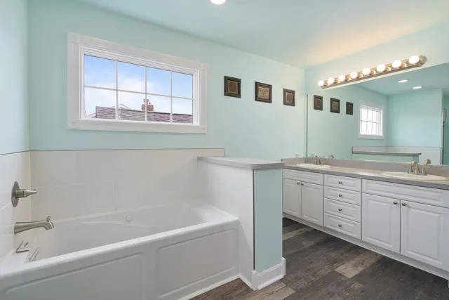 a bathroom with a tub sink and mirror