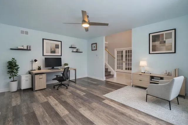 a view of a workspace with furniture and a window
