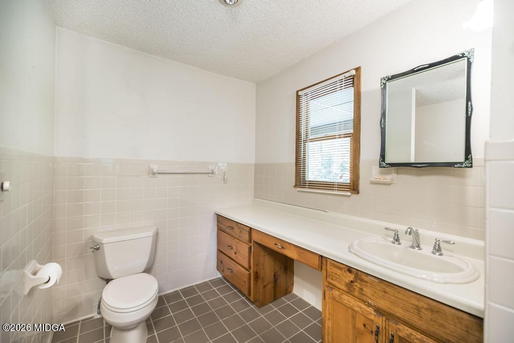 194 Delone Road Byron, GA 31008 - Photo 23 of 49 a bathroom with a granite countertop toilet sink and mirror