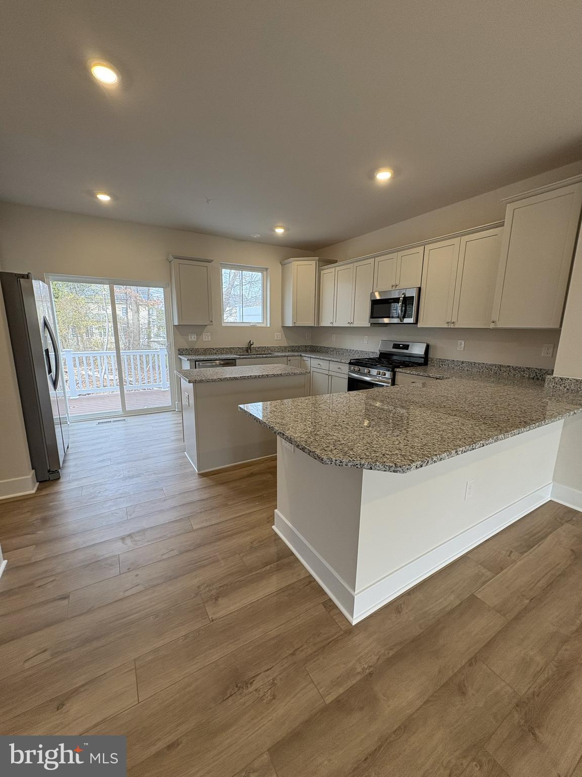 7448 Cornerstone Way Laurel, MD 20707 - Photo 3 of 13 a large kitchen with stainless steel appliances granite countertop a lot of counter space and wooden floors