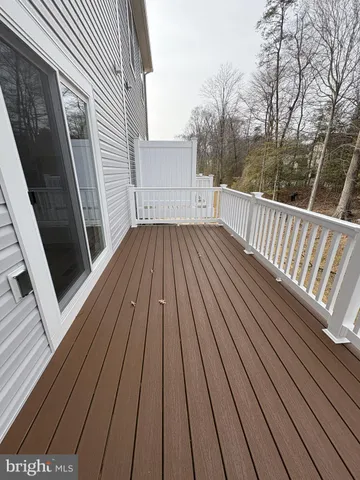 a view of deck with wooden floor and fence next to a yard