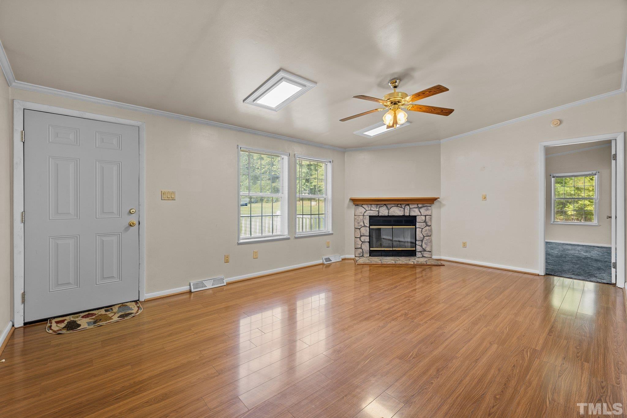 4505 Guess Road Rougemont, NC 27572 - Photo 4 of 33 an empty room with windows fireplace and a ceiling fan
