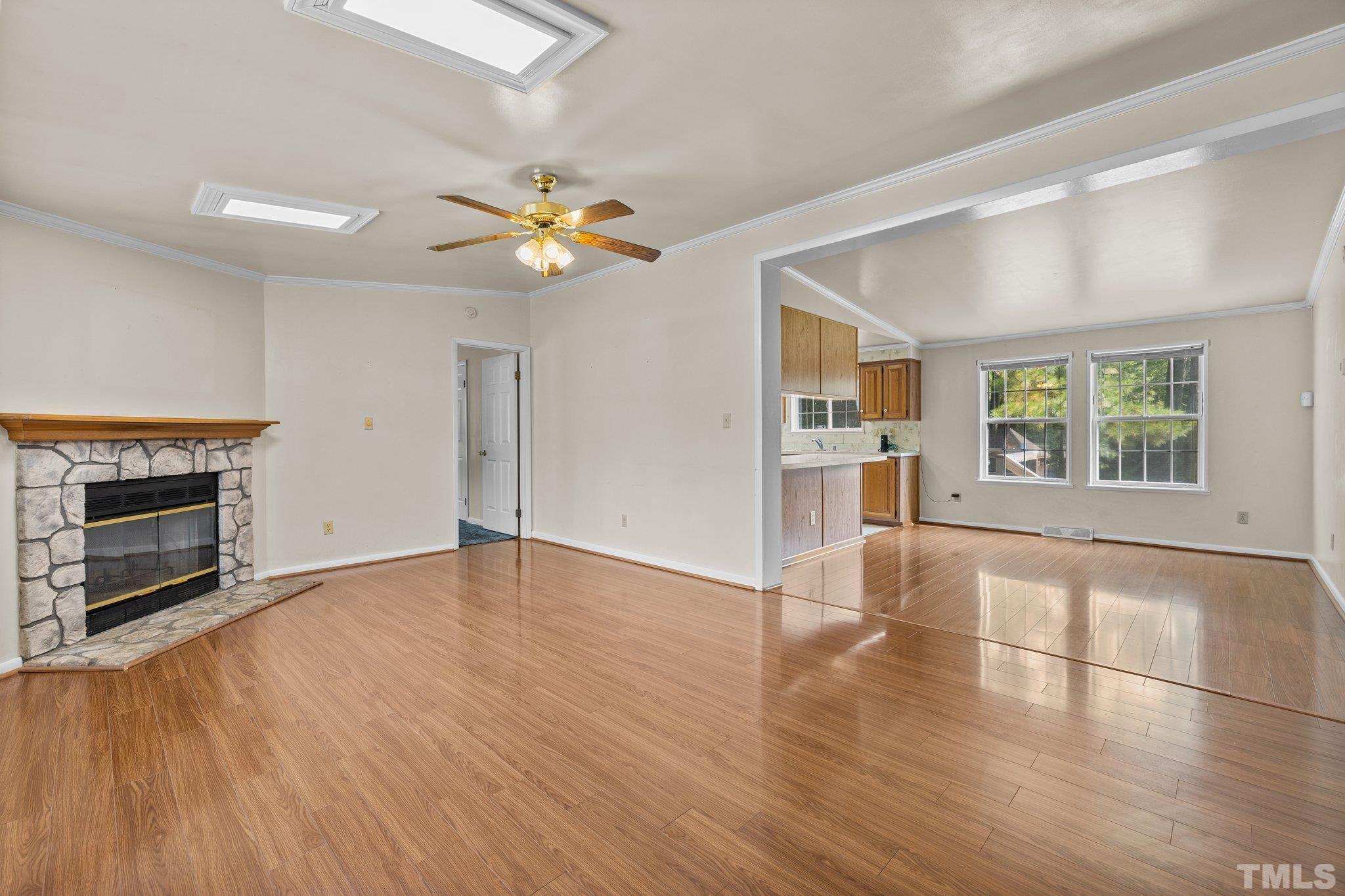 4505 Guess Road Rougemont, NC 27572 - Photo 5 of 33 an empty room with wooden floor fireplace and windows