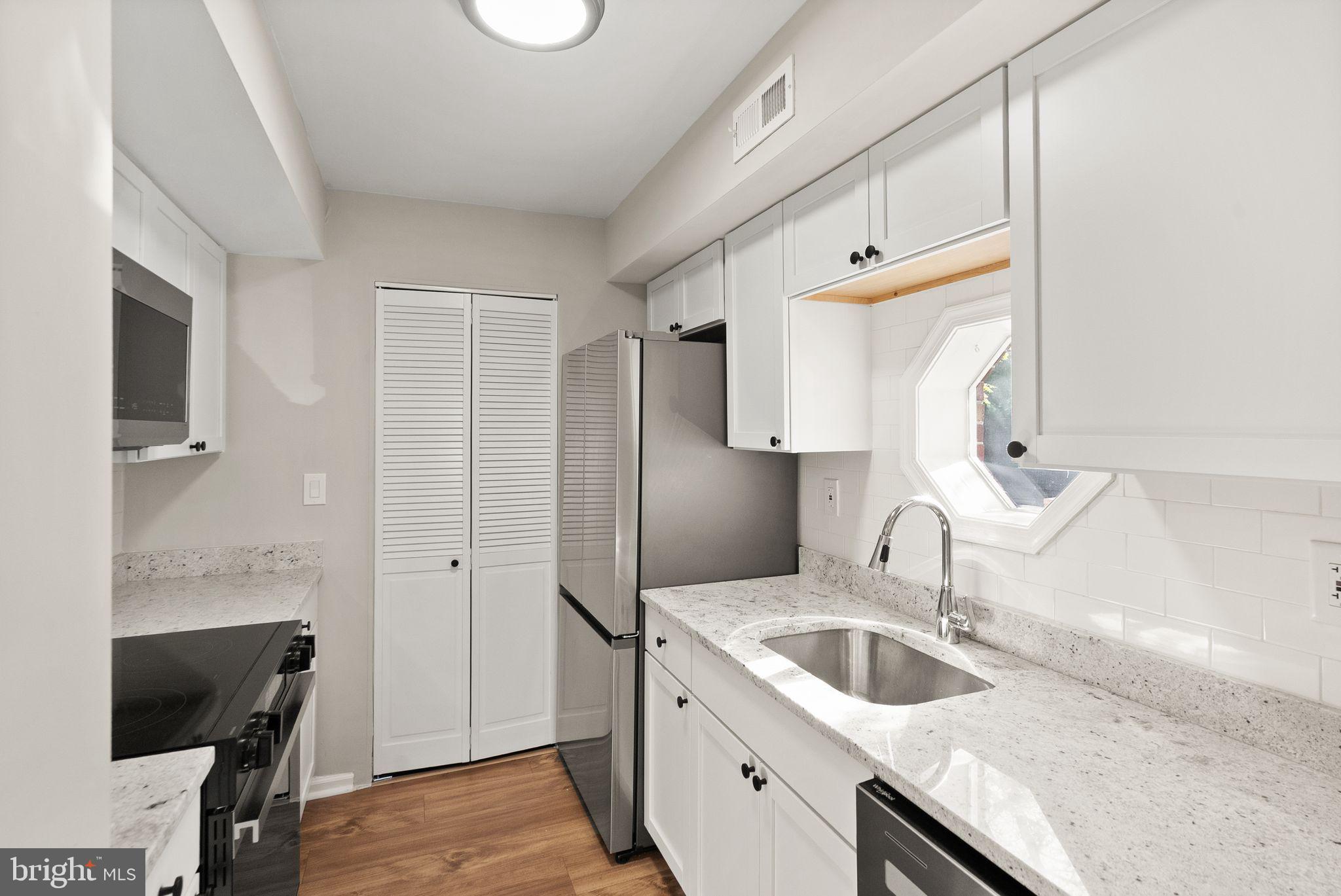 2592 South Arlington Mill Drive, Unit 7 Arlington, VA 22206 - Photo 13 of 44 a kitchen with a sink and a refrigerator