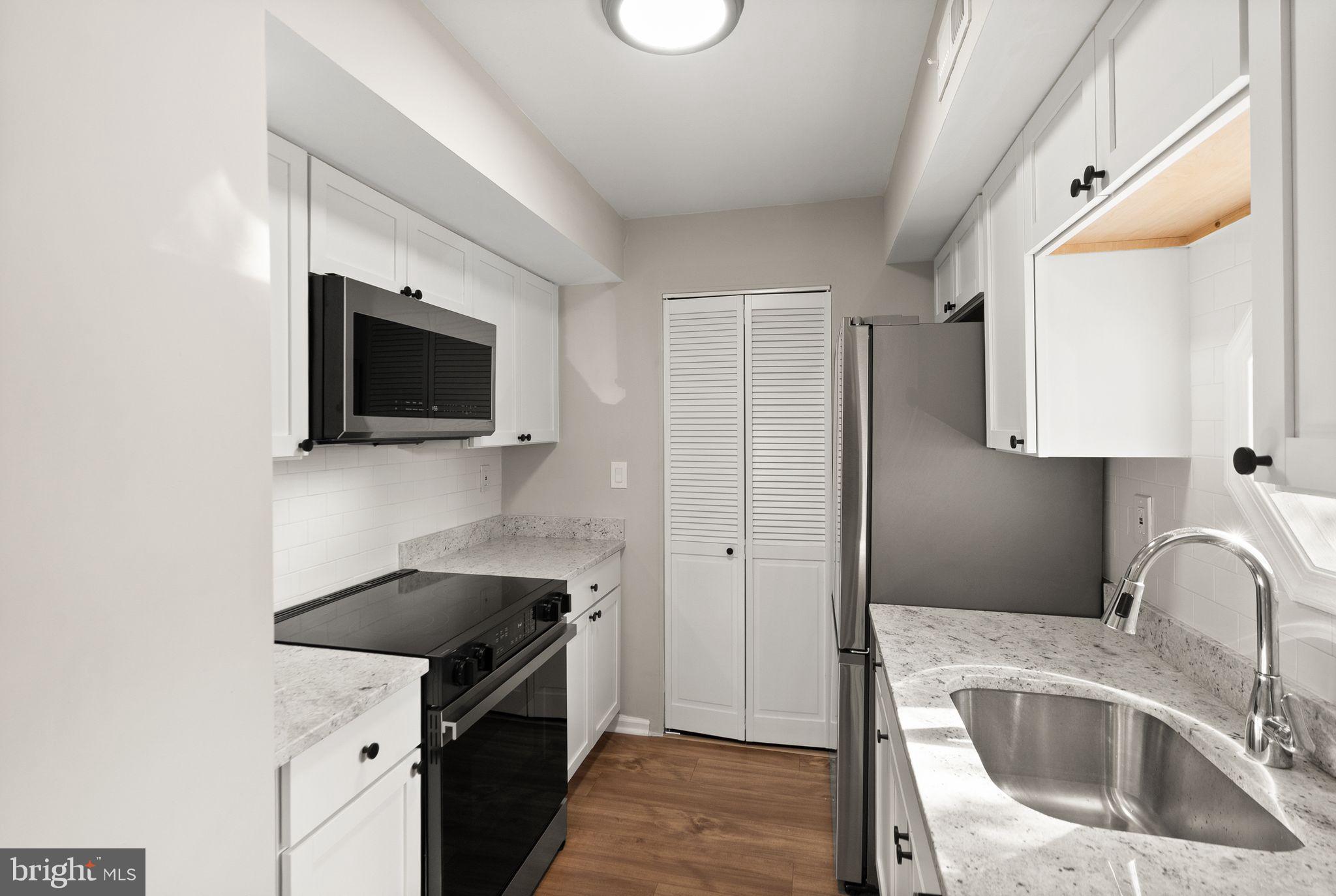 2592 South Arlington Mill Drive, Unit 7 Arlington, VA 22206 - Photo 14 of 44 a kitchen with stainless steel appliances wooden cabinets a sink a stove and a refrigerator