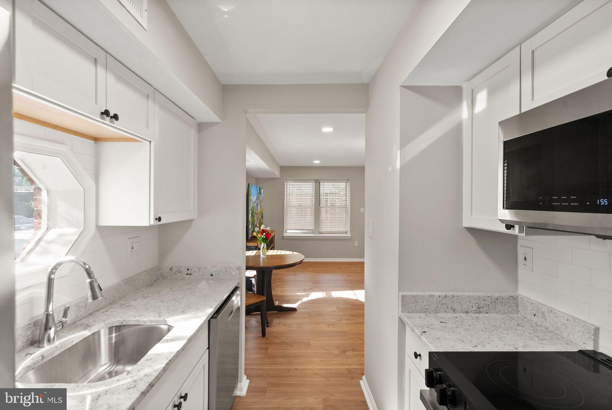 2592 South Arlington Mill Drive, Unit 7 Arlington, VA 22206 - Photo 16 of 44 a kitchen with a sink a counter top space and a view of living room