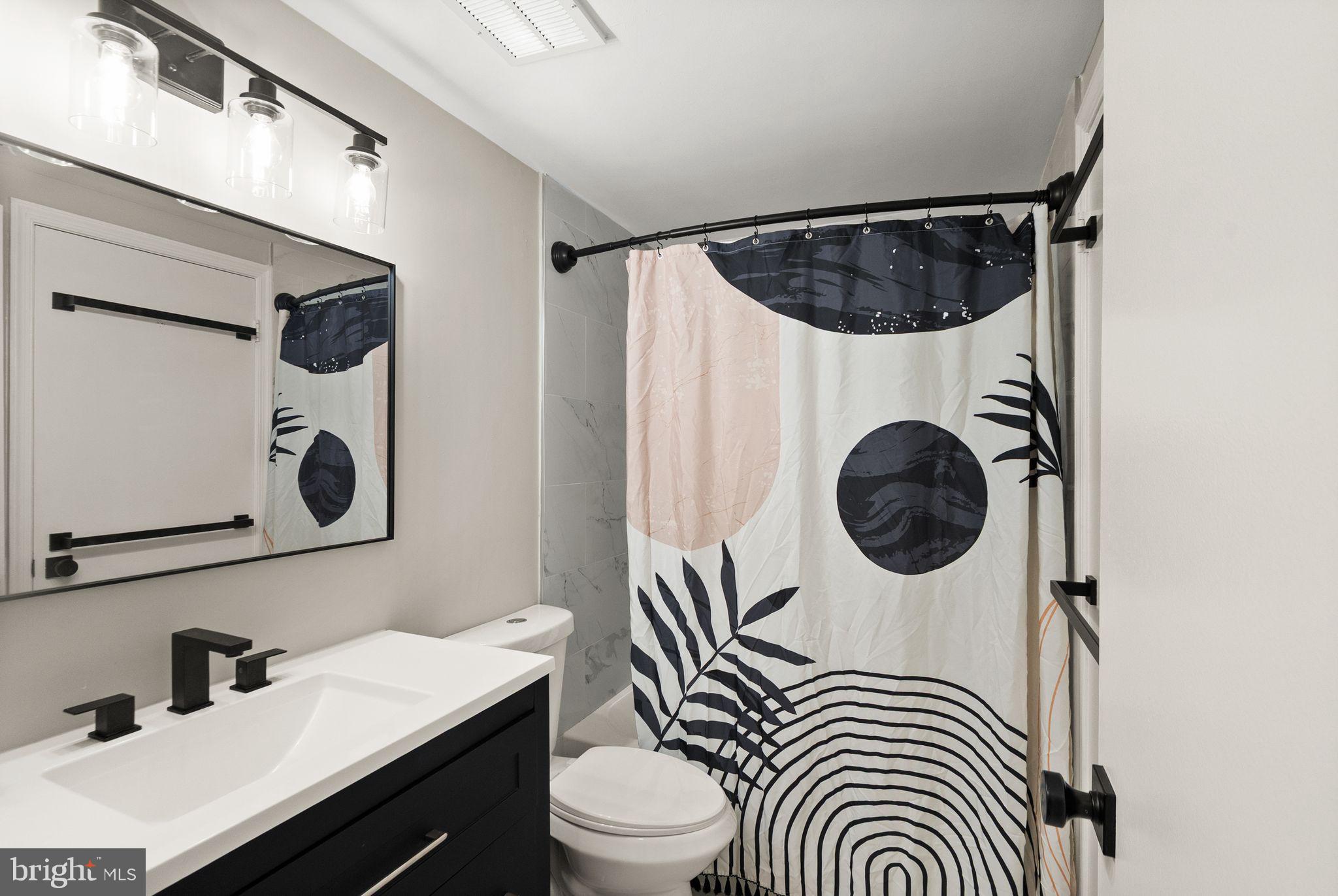 2592 South Arlington Mill Drive, Unit 7 Arlington, VA 22206 - Photo 21 of 44 a bathroom with a sink a toilet and mirror