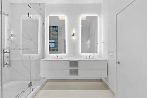 a bathroom with a granite countertop sink mirror and shower