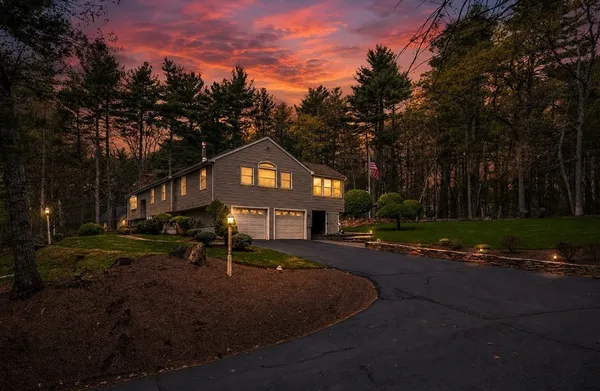 a front view of a house with a yard and trees