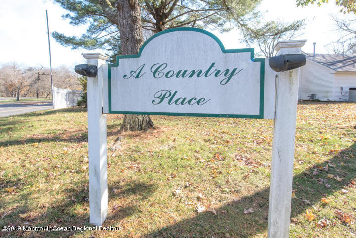 127 B Azalea Court, Unit 1002 Lakewood, NJ 08701 - Photo 1 of 10 a sign broad on the side of the road