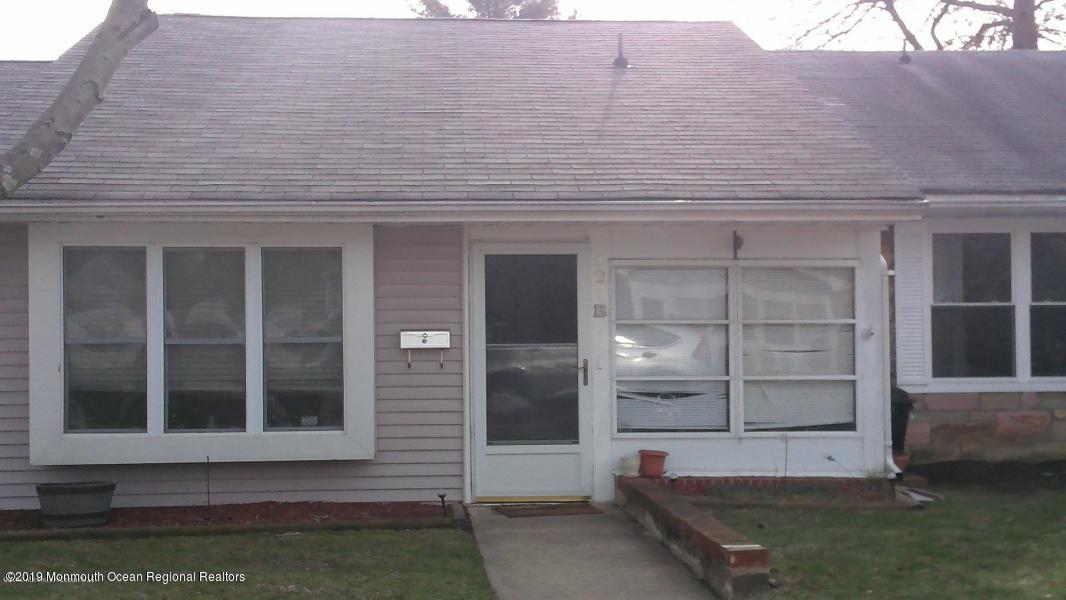 127 B Azalea Court, Unit 1002 Lakewood, NJ 08701 - Photo 2 of 10 a front view of a house with a yard