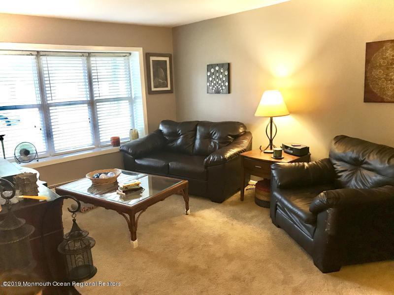 127 B Azalea Court, Unit 1002 Lakewood, NJ 08701 - Photo 3 of 10 a living room with furniture and a lamp