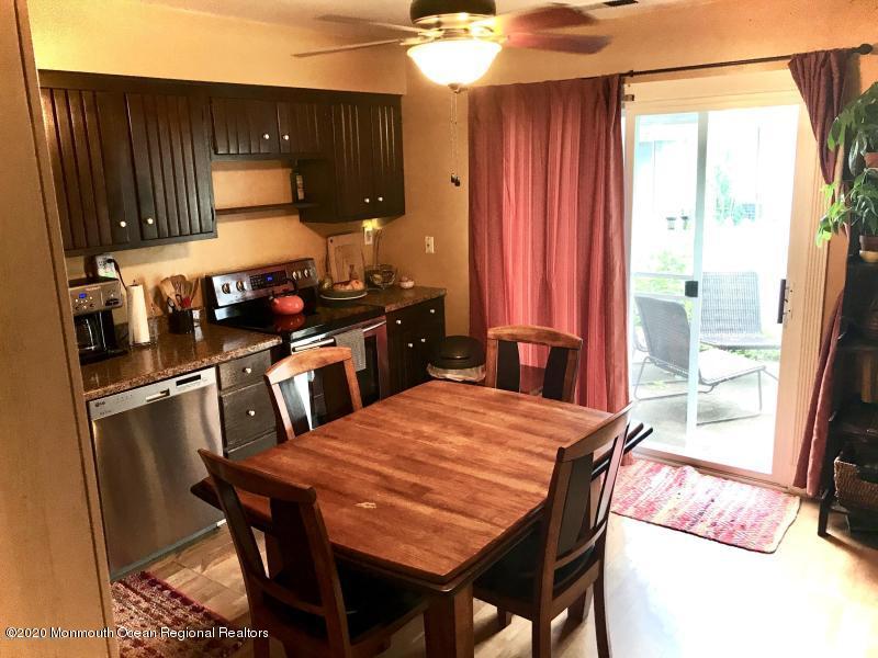 127 B Azalea Court, Unit 1002 Lakewood, NJ 08701 - Photo 5 of 10 a kitchen with stainless steel appliances kitchen island granite countertop a sink a stove and a refrigerator
