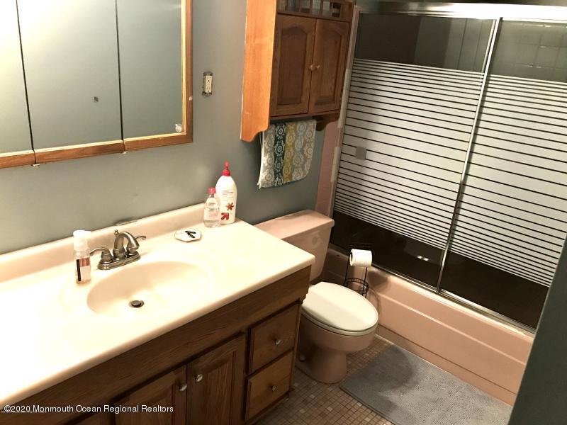 127 B Azalea Court, Unit 1002 Lakewood, NJ 08701 - Photo 7 of 10 a bathroom with a sink a toilet and mirror