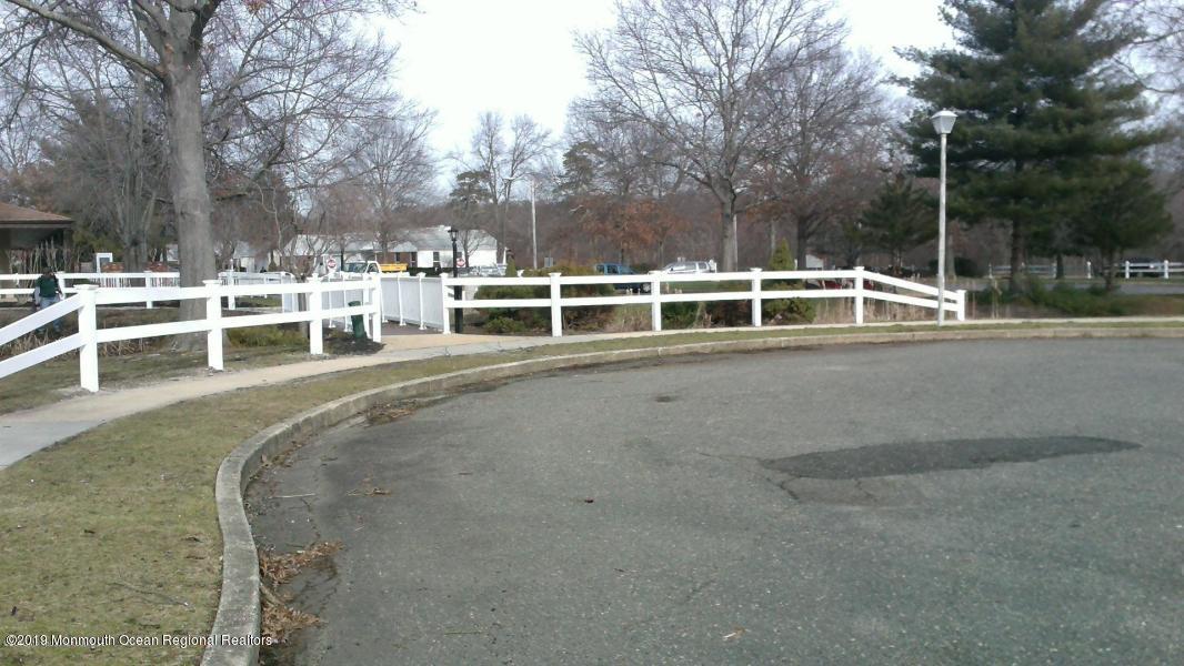 127 B Azalea Court, Unit 1002 Lakewood, NJ 08701 - Photo 9 of 10 a view of a swimming pool with a bench and trees