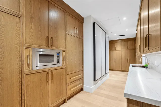 a view of a kitchen with stainless steel appliances wooden floor and chair
