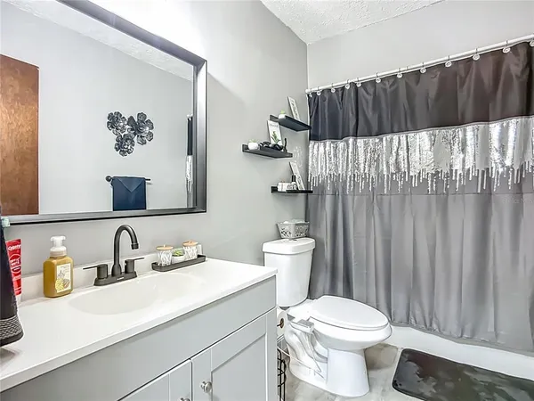 a bathroom with a sink a toilet and shower curtain