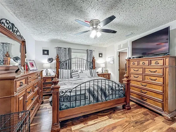 a view of a livingroom with furniture flat screen tv wooden floor and fan