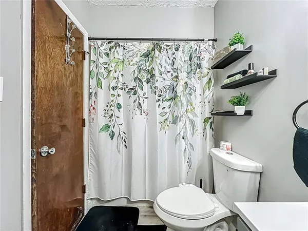 a white toilet sitting next to a shower curtain