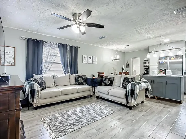 a living room with furniture ceiling fan and a window