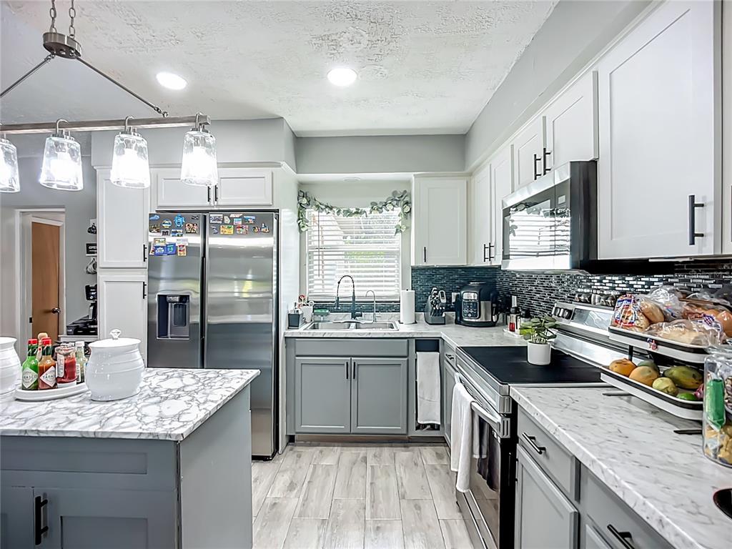 8016 Formby Street Riverview, FL 33578 - Photo 8 of 29 a kitchen with stainless steel appliances granite countertop a sink stove and refrigerator