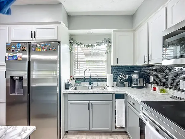 a kitchen with a refrigerator sink and cabinets