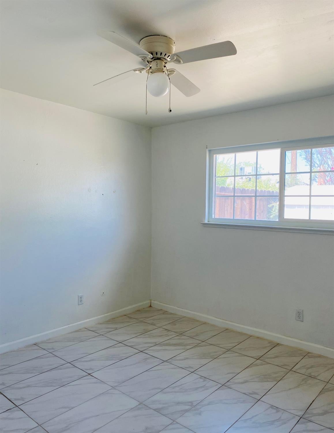 115 Gettysburg Avenue Clovis, CA 93612 - Photo 14 of 17 an empty room with a ceiling fan and window
