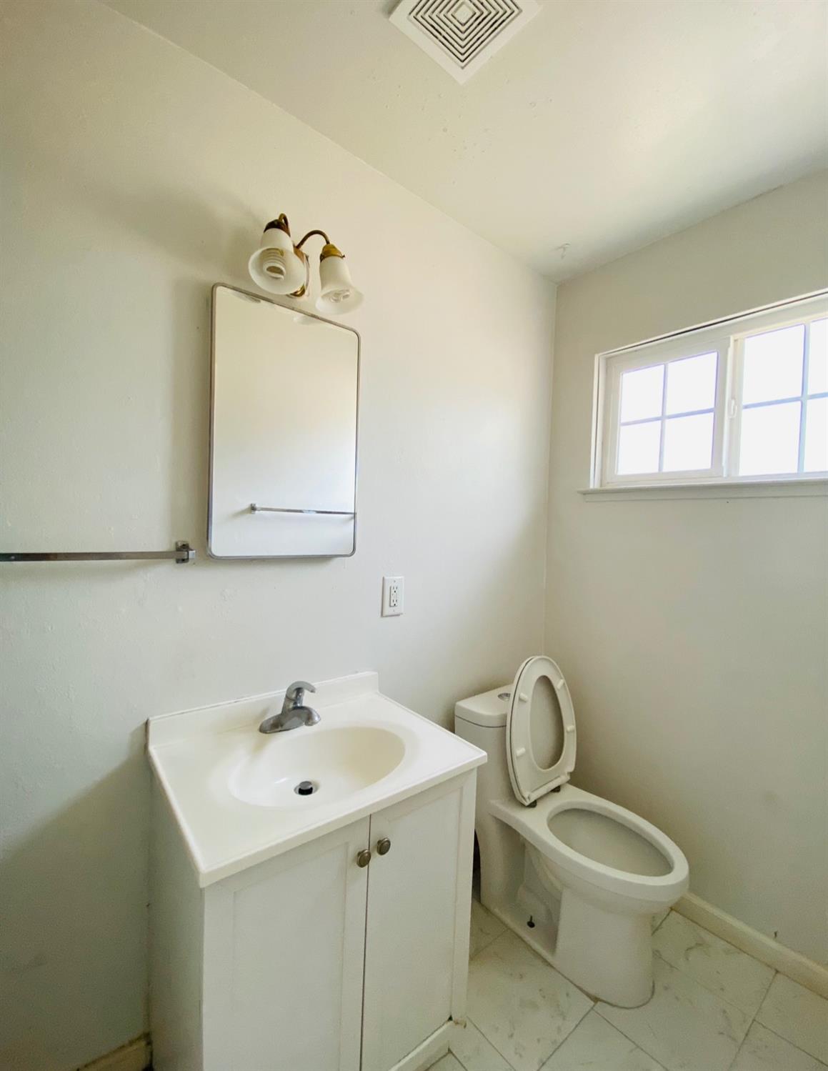 115 Gettysburg Avenue Clovis, CA 93612 - Photo 15 of 17 a bathroom with a toilet sink and mirror